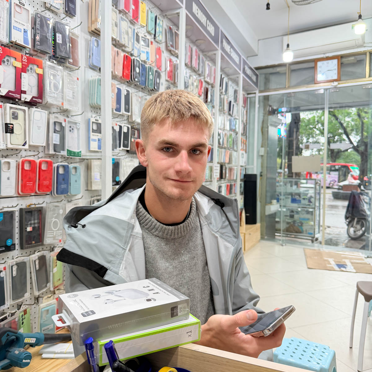 Customer checking repaired phone and accessories at Smartphone Accessories – Phone Repair Hanoi